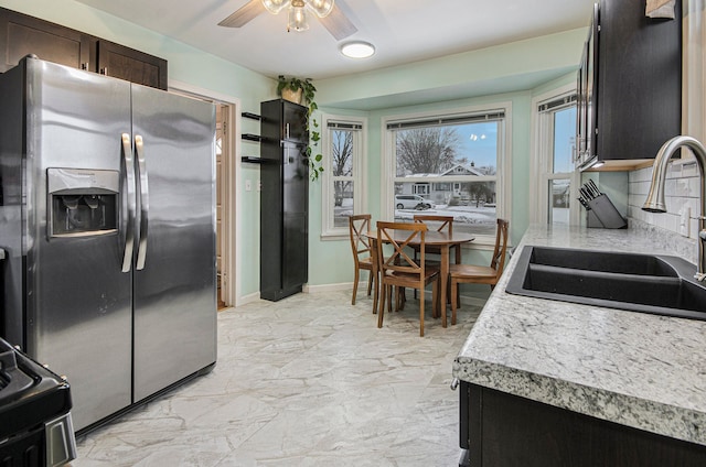 kitchen featuring sink, ceiling fan, dark brown cabinets, stainless steel fridge, and electric range