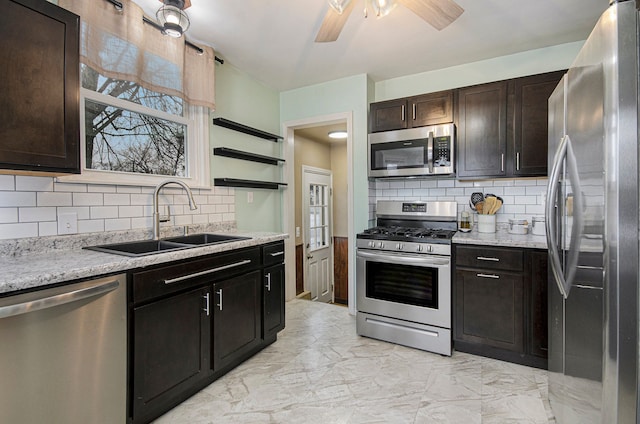 kitchen featuring sink, stainless steel appliances, light stone counters, and dark brown cabinetry