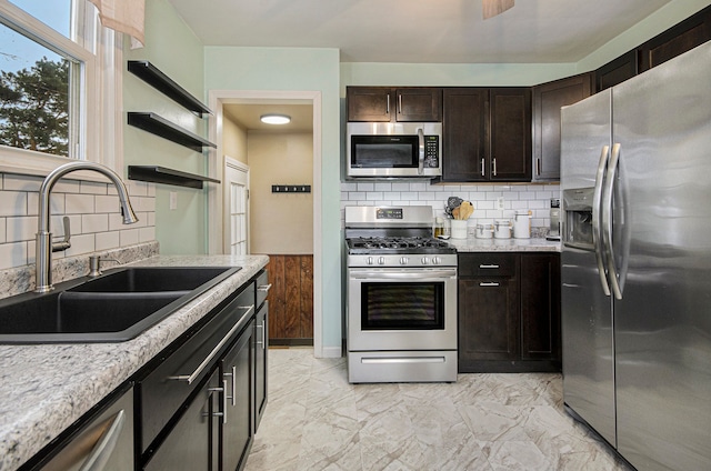 kitchen with sink, dark brown cabinetry, backsplash, and appliances with stainless steel finishes