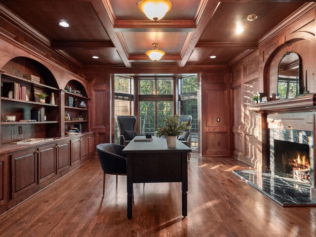 office featuring wooden walls, coffered ceiling, built in features, and crown molding