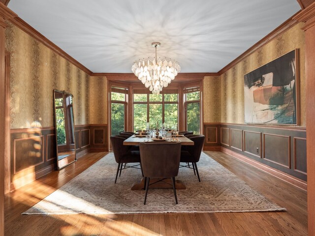 dining space featuring ornamental molding, a notable chandelier, and dark hardwood / wood-style floors