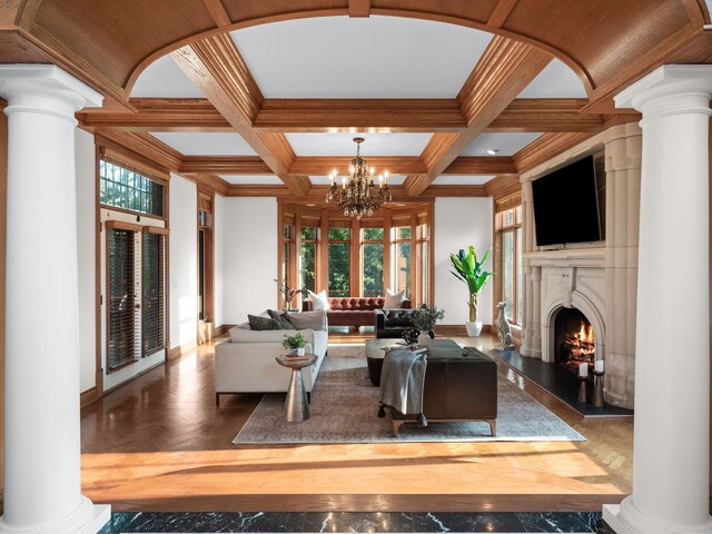 living room with parquet flooring, beamed ceiling, a healthy amount of sunlight, coffered ceiling, and a chandelier