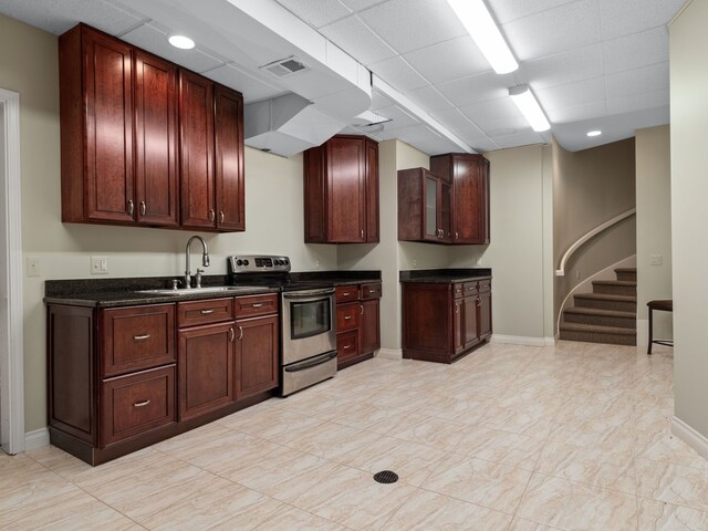 kitchen featuring a drop ceiling, electric stove, and sink