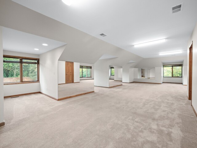 carpeted spare room with lofted ceiling and plenty of natural light