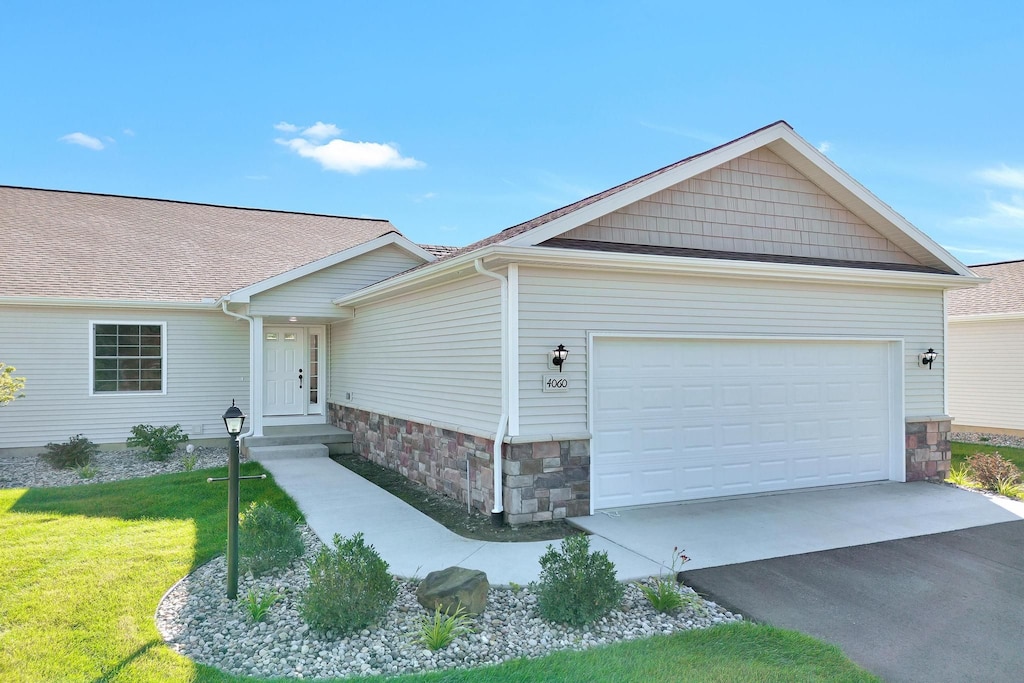 ranch-style house featuring a garage and a front lawn