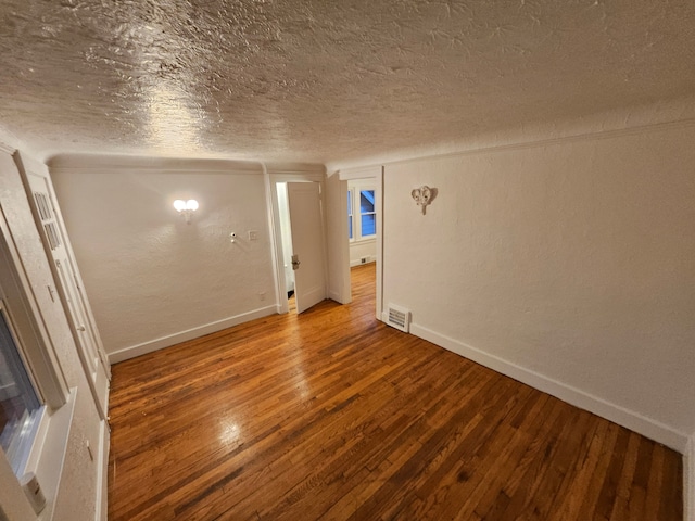 empty room with a textured ceiling and hardwood / wood-style floors