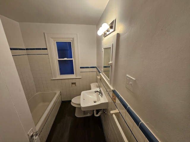 bathroom featuring wood-type flooring, a tub, sink, tile walls, and toilet