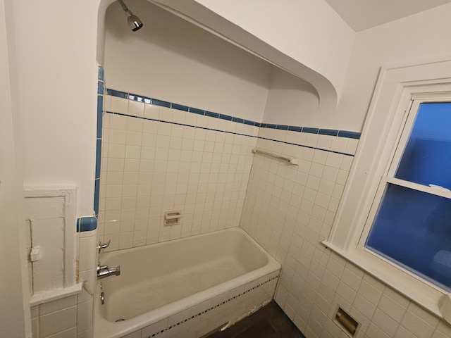 bathroom featuring shower / bathtub combination and tile walls