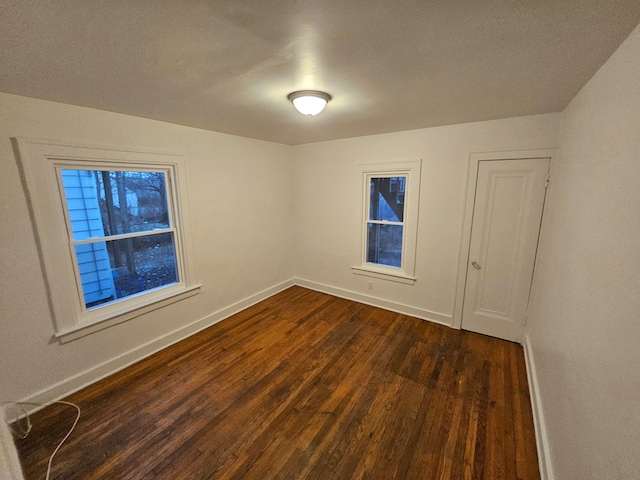 spare room with dark wood-type flooring