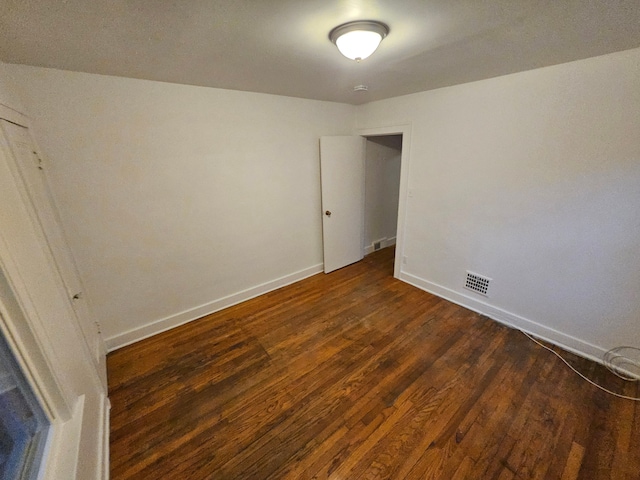 empty room with dark hardwood / wood-style flooring