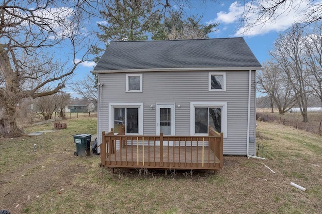 rear view of house with a lawn and a deck