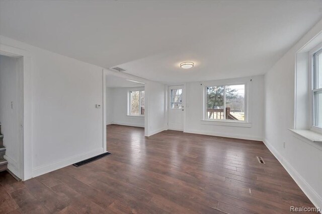 unfurnished room featuring a wealth of natural light and dark hardwood / wood-style flooring