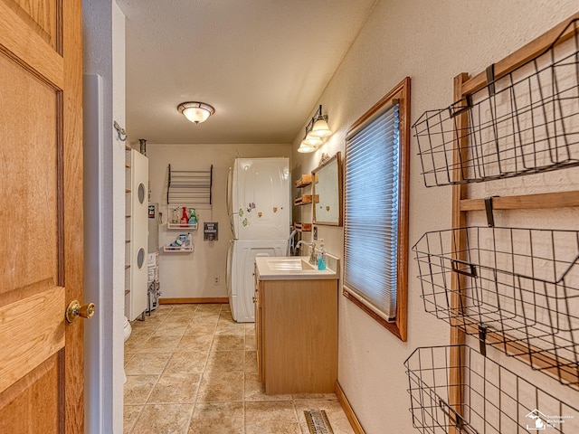 bathroom with vanity and stacked washing maching and dryer