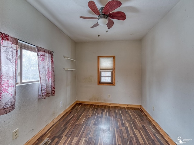 empty room featuring ceiling fan and dark hardwood / wood-style flooring