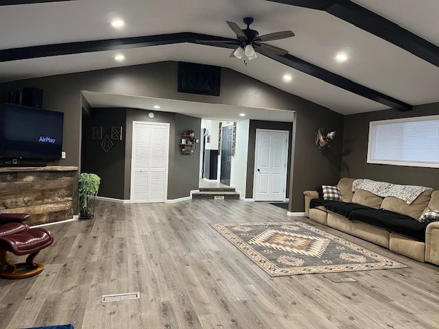 living room featuring ceiling fan, lofted ceiling with beams, and hardwood / wood-style flooring