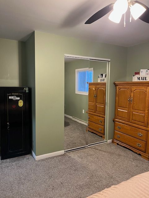 carpeted bedroom featuring ceiling fan and a closet