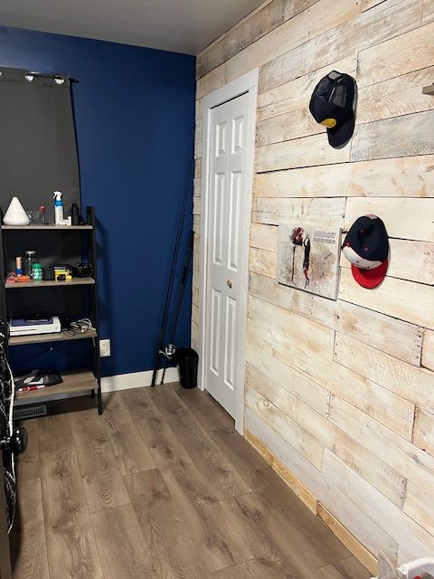 bedroom with hardwood / wood-style flooring and wood walls