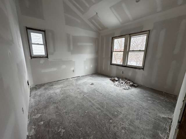 unfurnished room with lofted ceiling