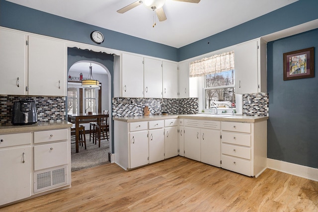 kitchen featuring white cabinets, sink, ceiling fan, tasteful backsplash, and light hardwood / wood-style floors