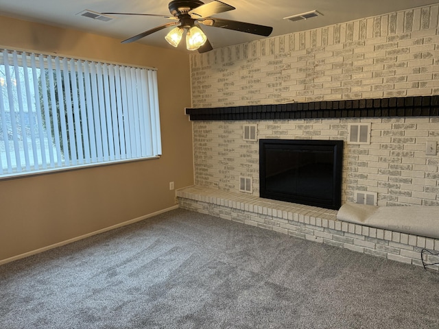 unfurnished living room featuring carpet, ceiling fan, and a brick fireplace