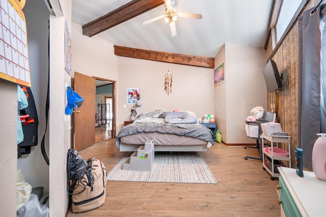 bedroom featuring a towering ceiling, ceiling fan, light hardwood / wood-style flooring, and beamed ceiling