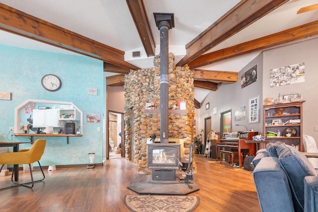 living room with beamed ceiling, wood-type flooring, high vaulted ceiling, and a wood stove