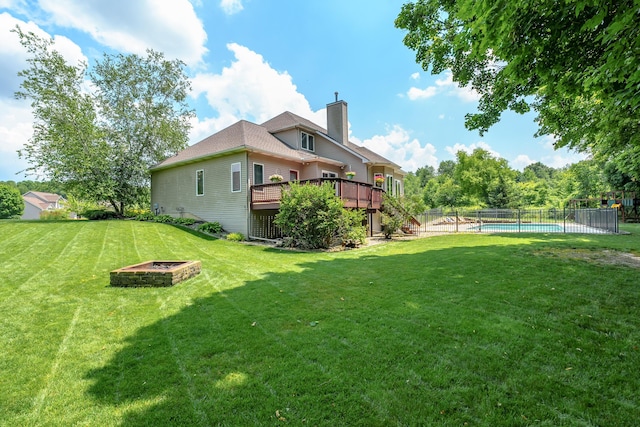 view of yard featuring a swimming pool side deck and an outdoor fire pit