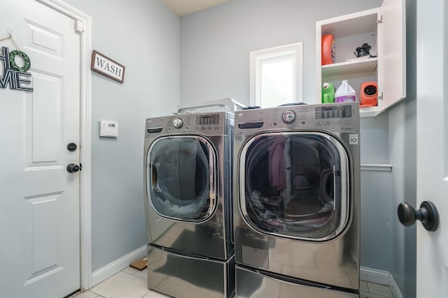 laundry area featuring washing machine and dryer and light tile patterned floors