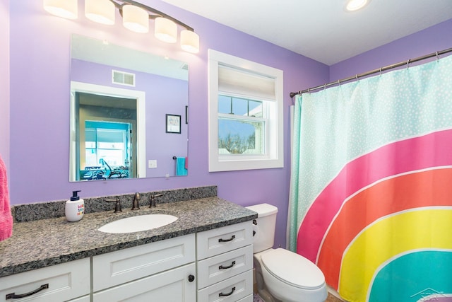 bathroom with a shower with shower curtain, plenty of natural light, toilet, and vanity