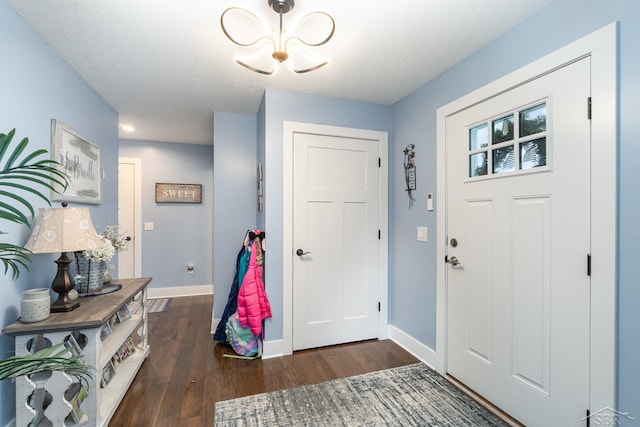 foyer featuring a textured ceiling and dark hardwood / wood-style floors