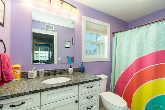 bathroom featuring vanity, a shower with shower curtain, and toilet