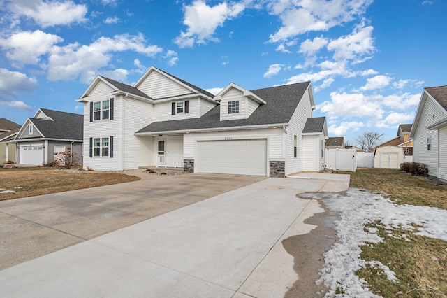 view of front facade with a garage, fence, concrete driveway, stone siding, and roof with shingles