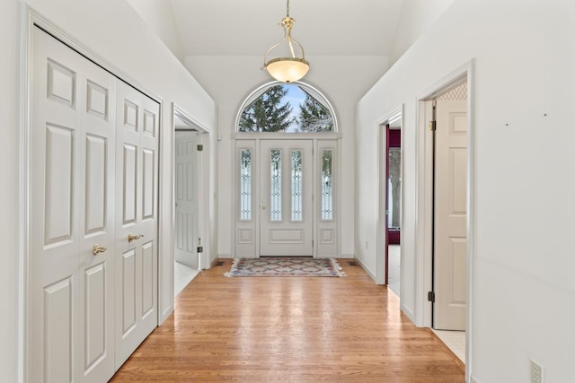 foyer with light hardwood / wood-style flooring and lofted ceiling