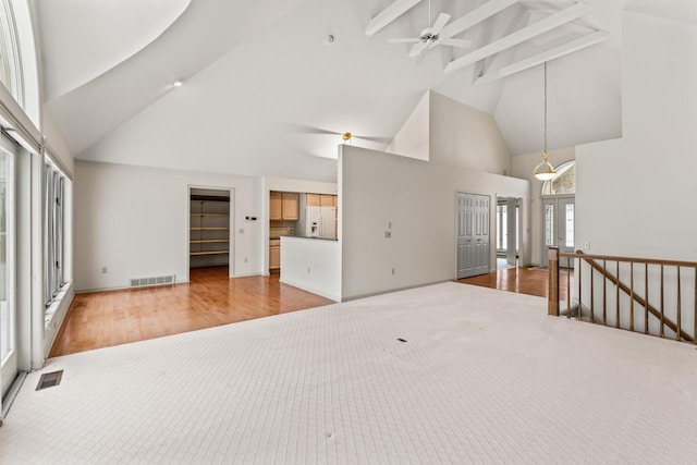 living room featuring beamed ceiling, ceiling fan, light carpet, and high vaulted ceiling