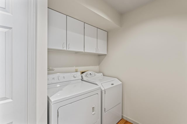 clothes washing area with cabinets and independent washer and dryer