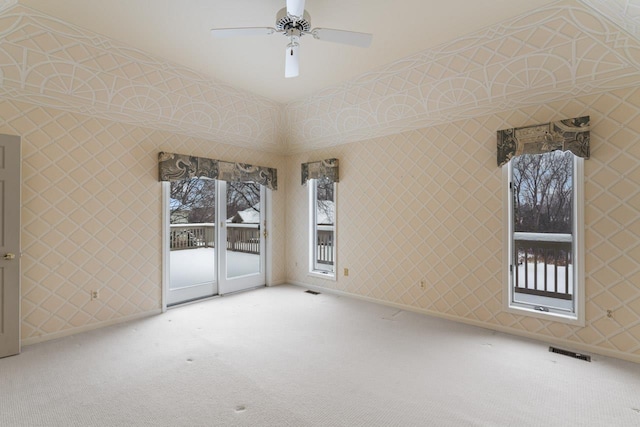 empty room featuring a high ceiling, carpet floors, and ceiling fan