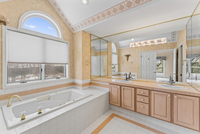 bathroom featuring vanity, a relaxing tiled tub, tile patterned floors, and a wealth of natural light