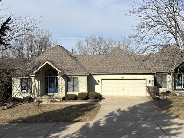 view of front facade featuring roof with shingles, concrete driveway, and an attached garage