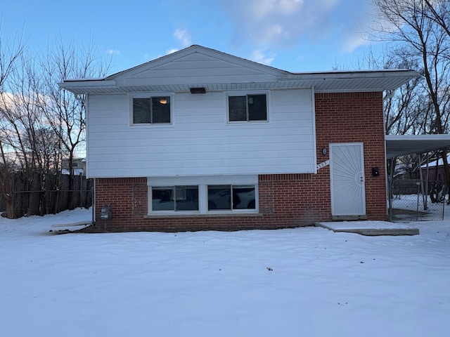 view of snow covered back of property