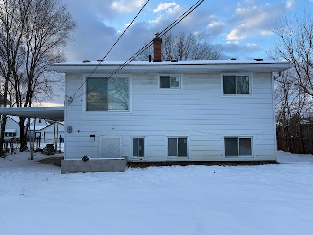 view of snow covered rear of property