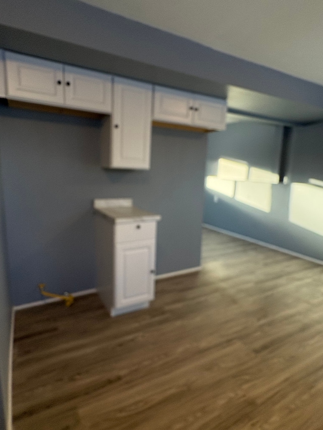 kitchen featuring hardwood / wood-style flooring and white cabinetry