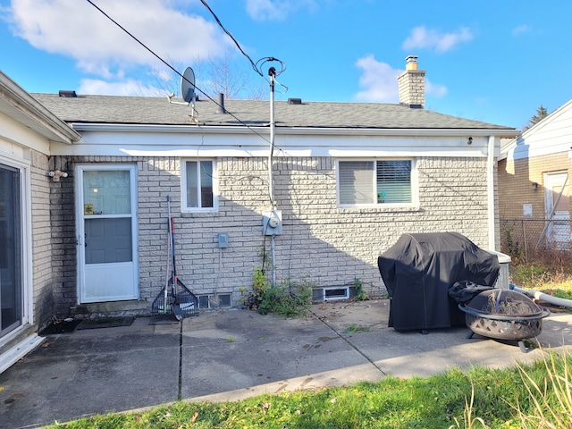 back of house with a fire pit and a patio area