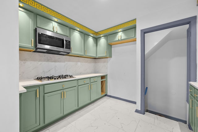 kitchen featuring backsplash, appliances with stainless steel finishes, and green cabinetry