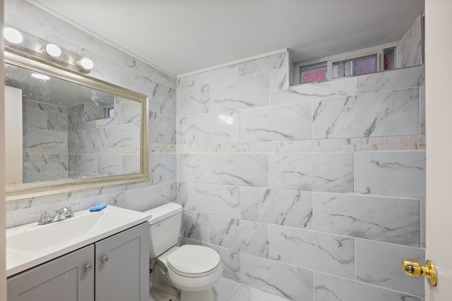 bathroom with tile walls, toilet, and vanity