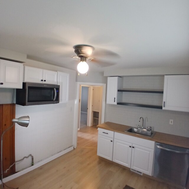 kitchen featuring sink, white cabinets, stainless steel appliances, and light wood-type flooring