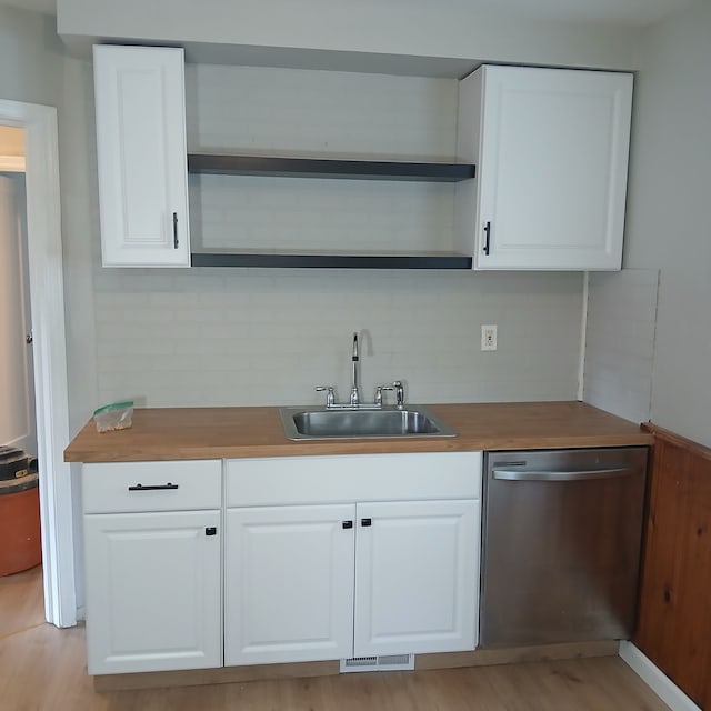 bar with sink, dishwasher, white cabinetry, backsplash, and wood counters