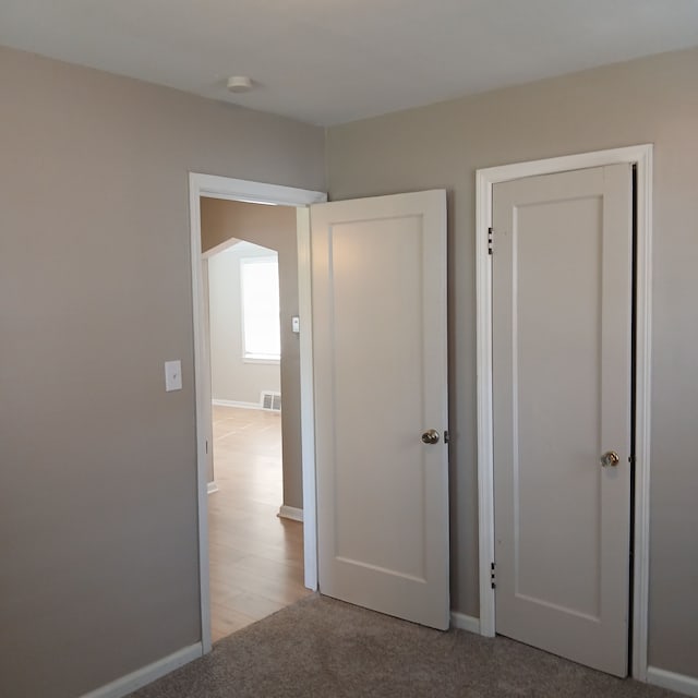 hall with light colored carpet