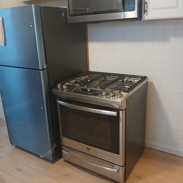 kitchen featuring tasteful backsplash, stainless steel appliances, and light hardwood / wood-style floors