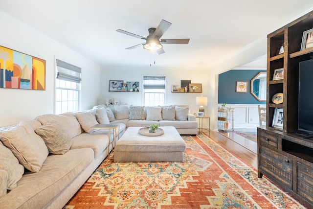 living room with hardwood / wood-style floors, ceiling fan, and ornamental molding