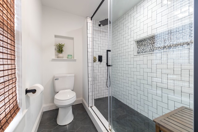 bathroom with tile patterned flooring, a tile shower, and toilet